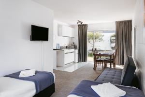a hotel room with two beds and a table at Roselands Motel in Tauranga