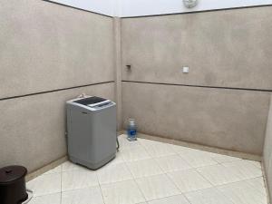 ein Badezimmer mit einem Mülleimer in der Ecke eines Zimmers in der Unterkunft Élégant appartement au cœur du Laâyoune in El Aaiún