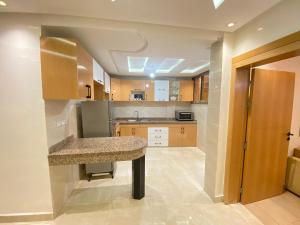 eine Küche mit einer Insel in der Mitte in der Unterkunft Élégant appartement au cœur du Laâyoune in El Aaiún