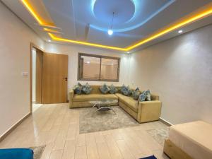 ein Wohnzimmer mit Sofa und Tisch in der Unterkunft Élégant appartement au cœur du Laâyoune in El Aaiún + 2 Fotos