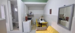 a living room with a yellow couch and a kitchen at Santa Ceciliers in Sao Paulo
