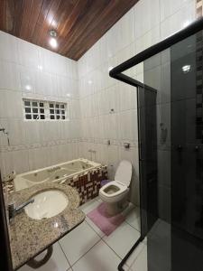 ein Badezimmer mit einer Badewanne, einem WC und einem Waschbecken in der Unterkunft Casa Lua Nova in Alto Paraíso de Goiás
