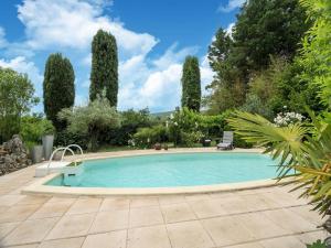 a swimming pool in a garden with trees at Majestic holiday home in Laroque with hot tub in Laroque