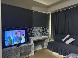 un soggiorno con una grande TV a schermo piatto di Henry's Newport Condotel a Manila