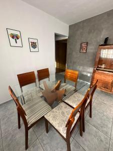 jadalnia ze szklanym stołem i krzesłami w obiekcie Apartamento VIP Centro Serra Negra - Familiar w mieście Serra Negra