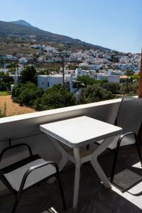 un tavolo bianco e sedie su un balcone con vista di Amelia rooms a Mpatsi (Batsi)