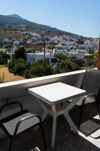 a white table and chairs on a balcony with a view at Amelia rooms in Batsi