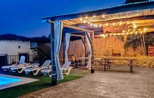 a pergola with a table and chairs next to a pool at Beautiful Home In Priego De Cordoba in Priego de Córdoba