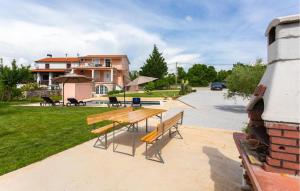 a picnic table and benches in a yard at Beautiful Apartment In Malinska in Malinska +17 photos