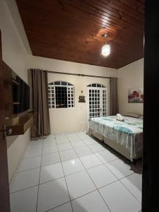 ein Schlafzimmer mit einem Bett und Fliesenboden in der Unterkunft Casa Lua Nova in Alto Paraíso de Goiás