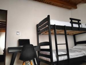 a room with two bunk beds and a desk with a laptop at Cómodo Departamento 2 Ambientes in Guaymallen