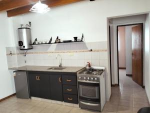a kitchen with a stove and a sink at Cómodo Departamento 2 Ambientes in Guaymallen