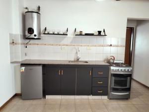 a kitchen with a sink and a stove at Cómodo Departamento 2 Ambientes in Guaymallen