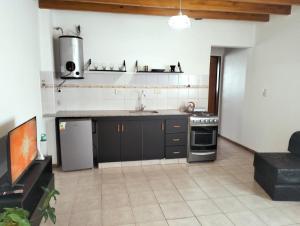 a kitchen with a sink and a stove at Cómodo Departamento 2 Ambientes in Guaymallen