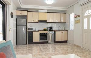 a kitchen with wooden cabinets and stainless steel appliances at Gorgeous Home In Ciudad Quesada in Ciudad Quesada