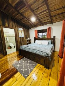 1 dormitorio con 1 cama y suelo de madera en Cabañas Litos #1, en Fortuna