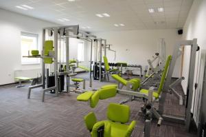 a gym with green chairs and machines in a room at Hotel Kaskada in Ledeč nad Sázavou