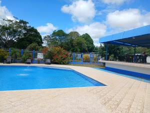 una piscina en un patio con una valla azul en Hotel campestre la Maria en Villavicencio