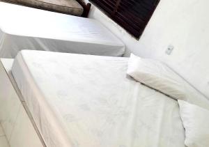 - deux lits blancs assis l'un à côté de l'autre dans l'établissement Hostel Summer Praia do Sol, à João Pessoa
