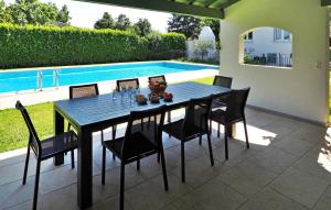 einen Esstisch mit Stühlen und einen Pool in der Unterkunft Villa Les Sapins in Moulès