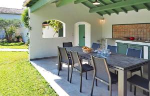 eine Terrasse mit Tisch und Stühlen und eine Küche in der Unterkunft Villa Les Sapins in Moulès