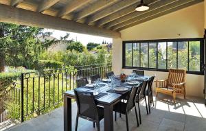 a dining room with a table and chairs on a balcony at Villa Les Sapins in Moulès