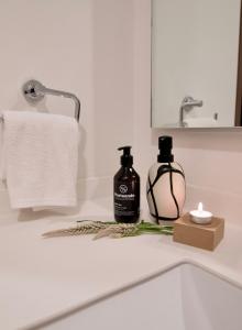 un lavandino in bagno con una bottiglia di sapone e una candela di SANTA FE Red Beautiful Apartment! a Città del Messico