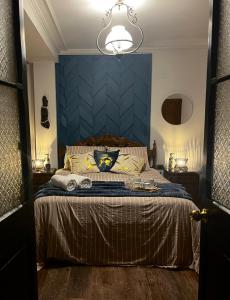 1 dormitorio con 1 cama grande y cabecero azul en Hab. privada en Cité histórico del barrio Yungay, en Santiago