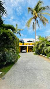 uma palmeira em frente a uma casa amarela em Ixaya em Puerto Vallarta