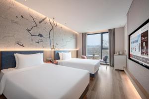 Postel nebo postele na pokoji v ubytování IntercityHotel Jingdezhen Taoxichuan