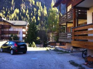 a car parked in a parking lot next to a building at Appartamento Ivo in Campitello di Fassa