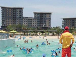 a group of people in a swimming pool at Welcome Homestay Waterfront in Darwin