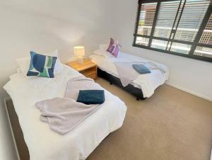 a bedroom with two beds and a window at Welcome Homestay Waterfront in Darwin +18 photos