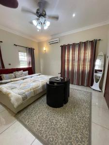 a bedroom with a bed and a table on a rug at Chez nous house in Accra