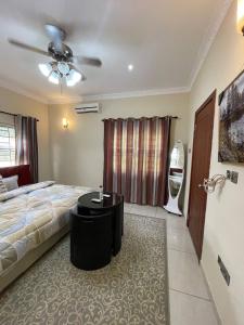 sypialnia z łóżkiem i wentylatorem sufitowym w obiekcie Chez nous house w Akrze