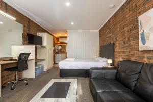 旺萨吉Wonthaggi Motel的配有床和沙发的酒店房间