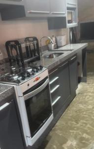 a kitchen with a stove and a sink at Casa com piscina in Cianorte