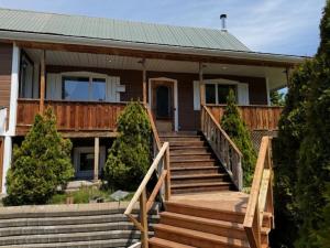 a house with stairs leading to the front door at Le Chadou in Tadoussac