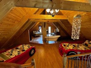 a attic room with two beds and a bath tub at Le Chadou in Tadoussac