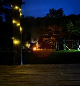 un incendie brûle dans une maison la nuit dans l'établissement Lakefront Hideaway Resort 10 Total cabins-Lake View, Private Beach, à Kawartha Lakes