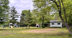 un parc avec une maison et une aire de jeux dans l'établissement Lakefront Hideaway Resort 10 Total cabins-Lake View, Private Beach, à Kawartha Lakes 24 autres photos