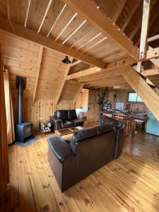 a living room with a leather couch and a fireplace at Vista Hermosa Laguna Verde in Laguna Verde