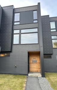 une maison grise avec une porte de garage en bois dans l'établissement Bootlegger's Nest, à Anchorage