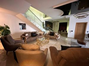a large living room with couches and a staircase at Boulevard Palace in Sheikh Zayed
