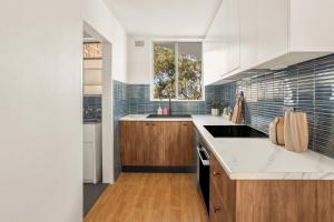 une cuisine avec des armoires blanches et un comptoir dans l'établissement Glebe Tranquil Retreat - 2bd with parking, à Sydney