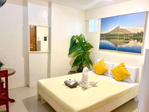 Zimmer mit einem Bett und einem Gemälde an der Wand in der Unterkunft Casa Bicolandia Suites in Locsin
