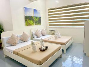 a room with two beds and a window at Casa Bicolandia Suites in Daraga