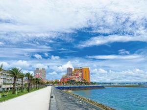 a walkway next to a body of water with buildings at Sunset Resort Mihama -SEVEN Hotels and Resorts- in Chatan