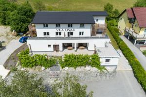 an aerial view of a white house with a black roof at VILA LISJAK - Apartments in Podčetrtek
