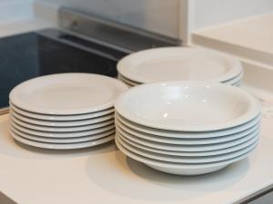 tres pilas de platos blancos sentados en un mostrador en Sunset Resort Mihama -SEVEN Hotels and Resorts-, en Chatan